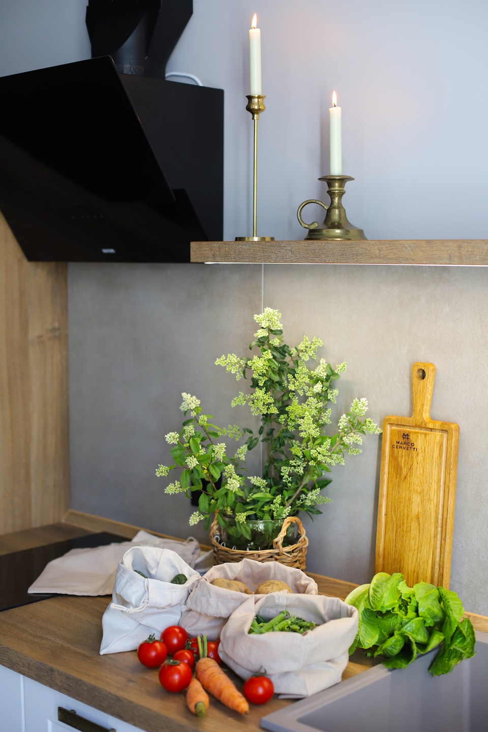 Fresh vegetables are arranged on a clean wooden kitchen counter.